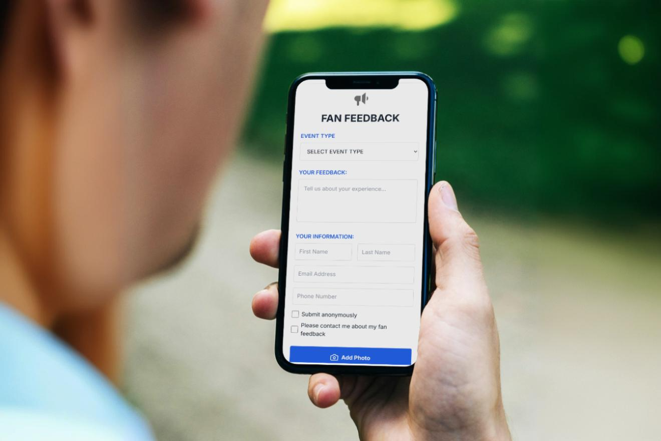 Hand holding mobile phone showing fan feedback form